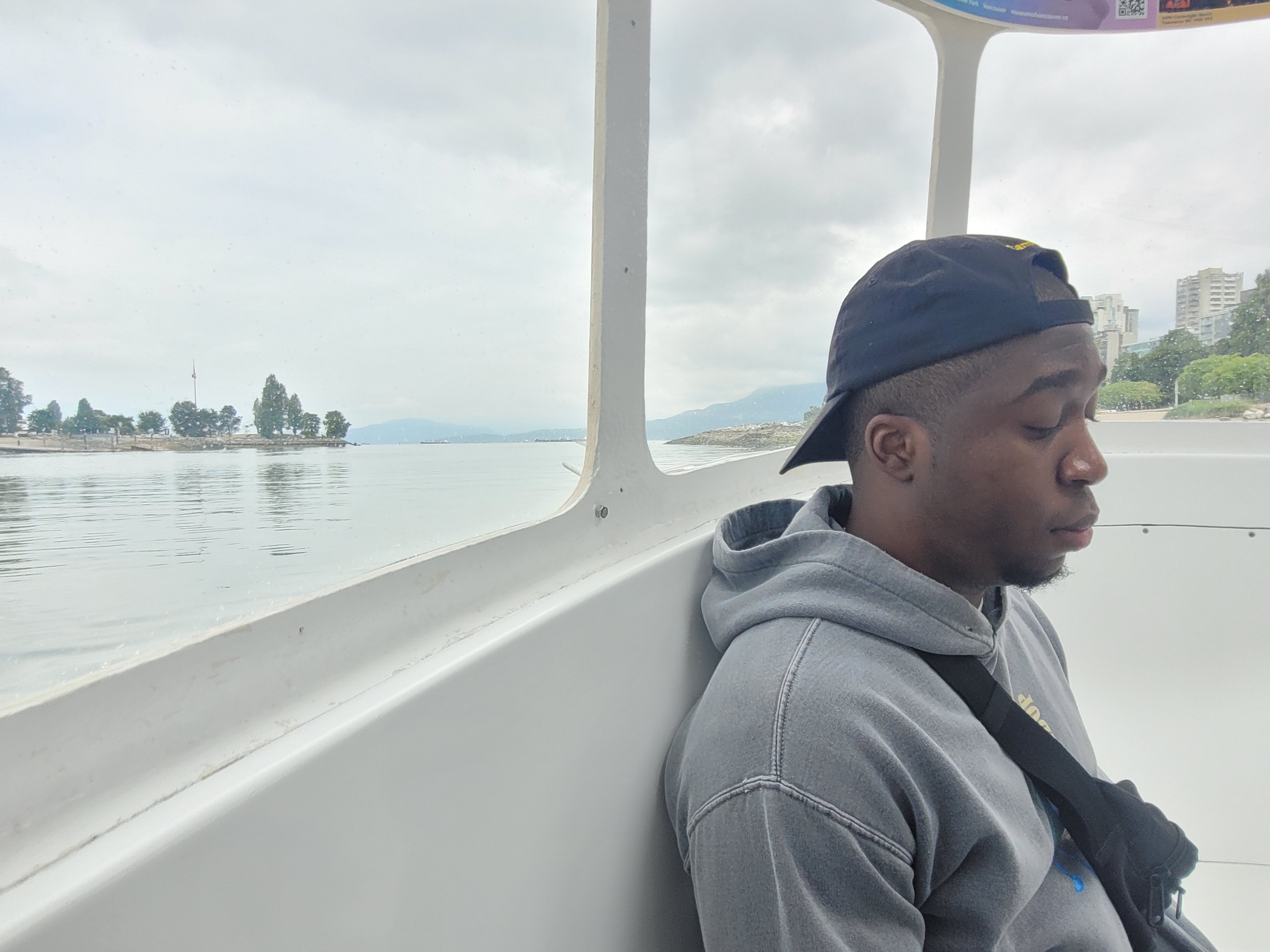 Dane staring down at his camera while on a boat